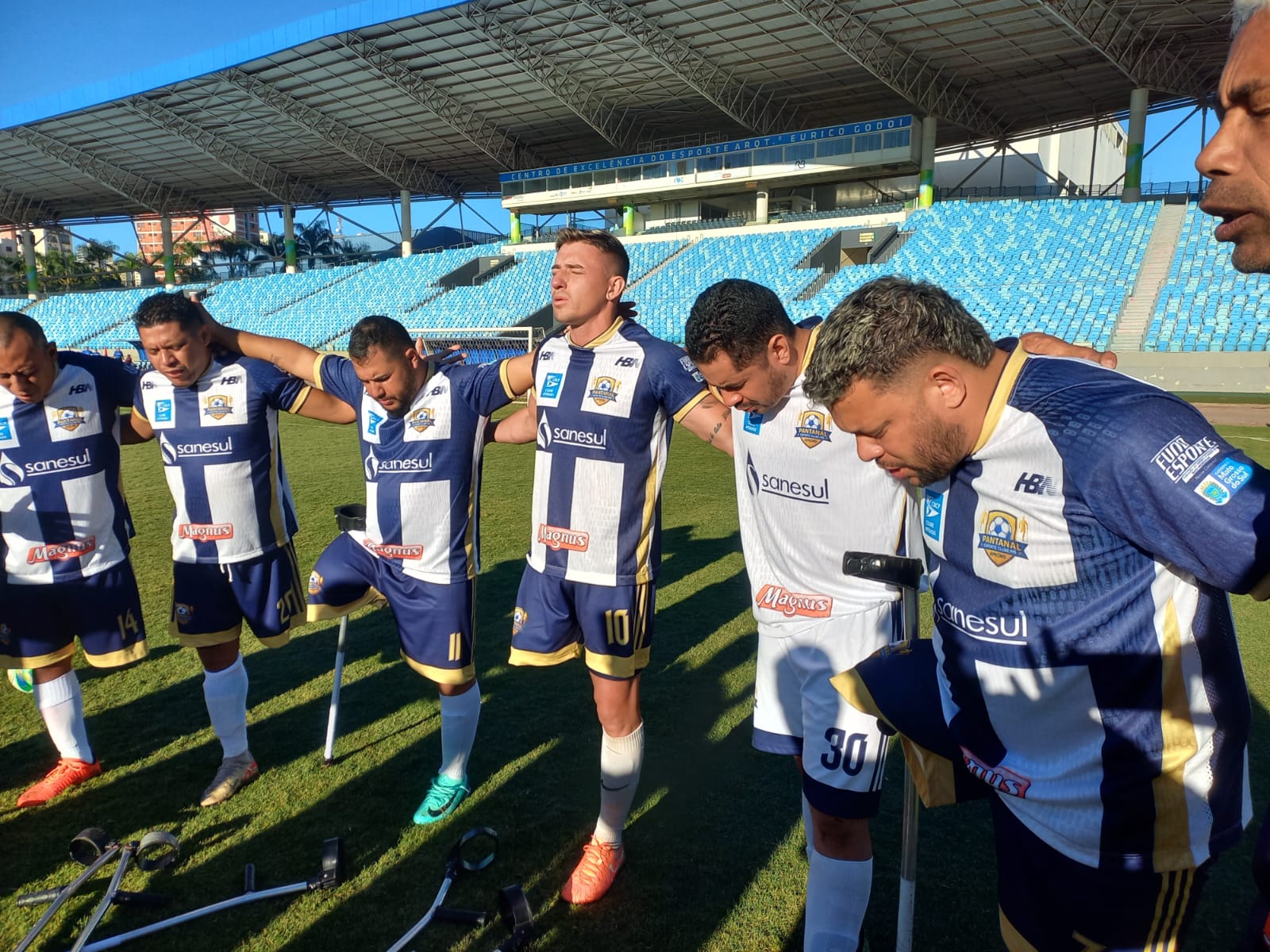 Atletas reunidos em círculo no campo